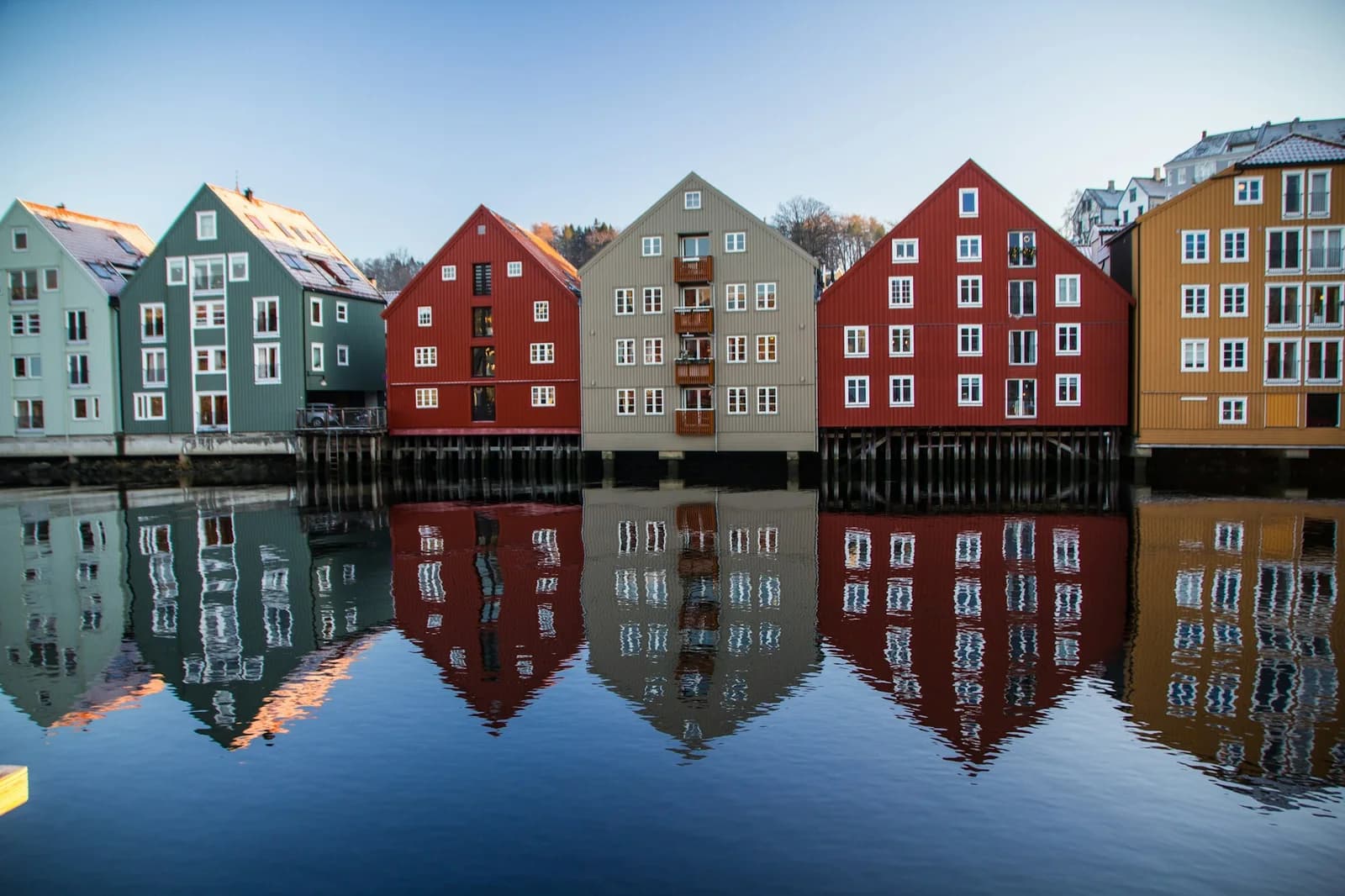 Fargerike bryggehus speiler seg i Nidelva i Trondheim