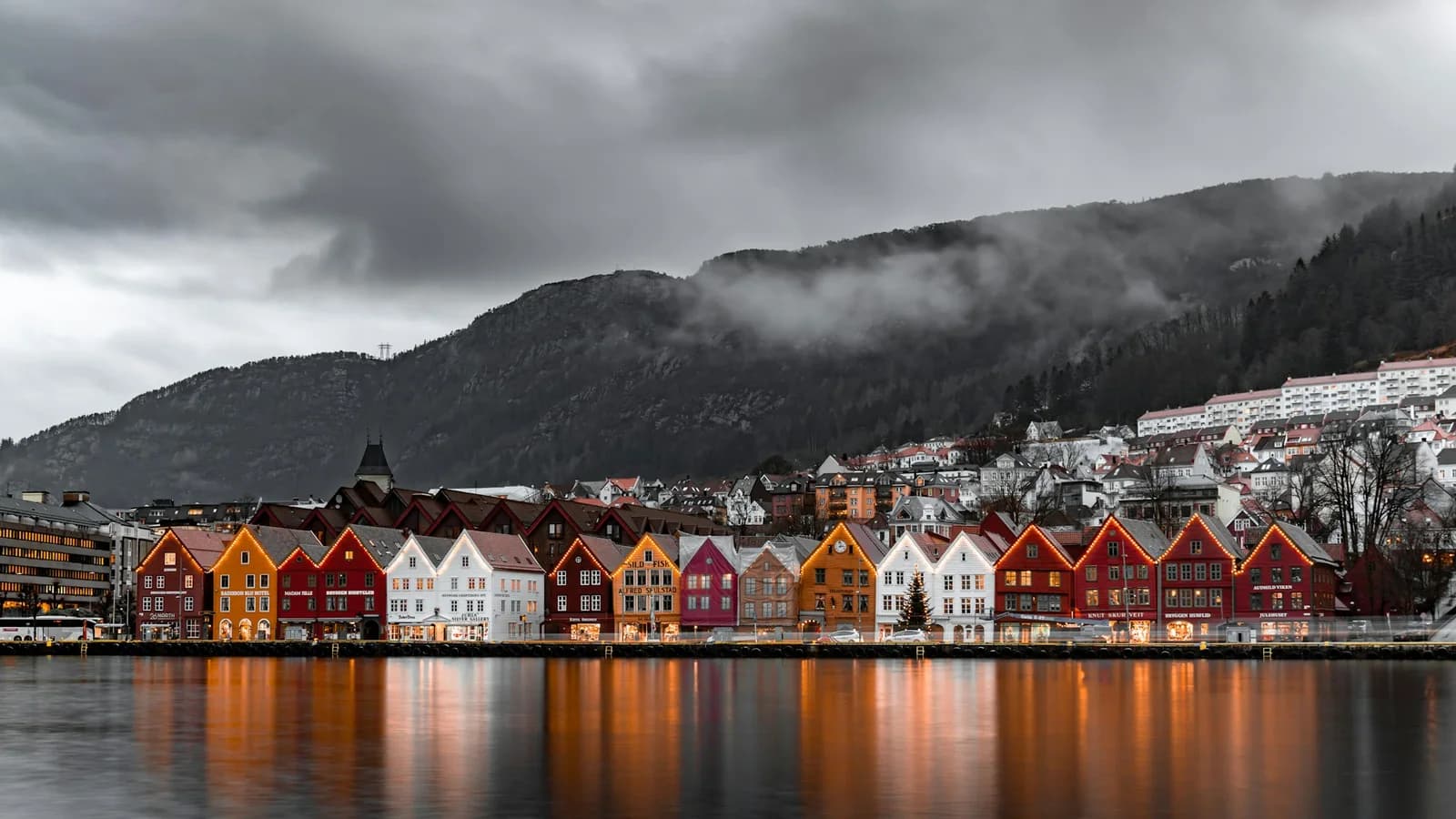 Fargerike trehus på Bryggen i Bergen med fjell bak